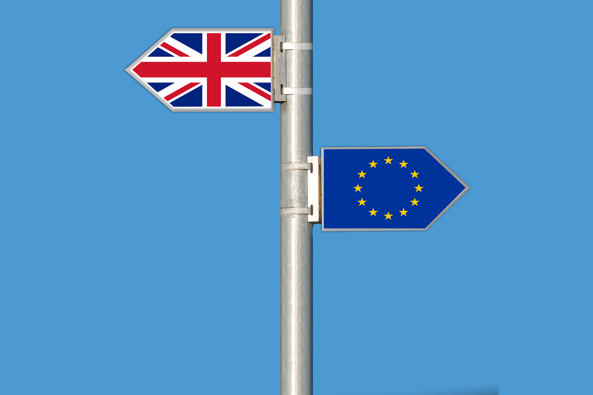 UK flag, EU flag pointing different directions for Brexit